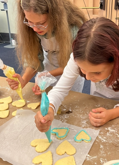 Maria Pryshliak and Kateryna Bratko decorate their cookies
