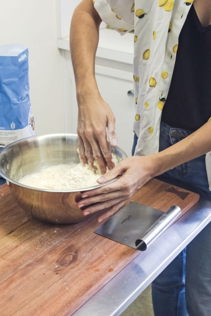 Use one hand to mix and the other to hold the bowl. Mix with your hands until the dough comes together.  