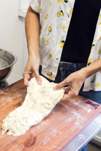 On a lightly floured surface, pick up your dough with both hands.