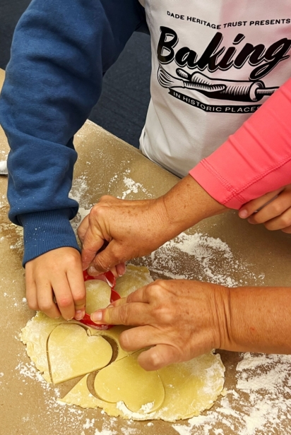 Young bakers get help cutting out hearts