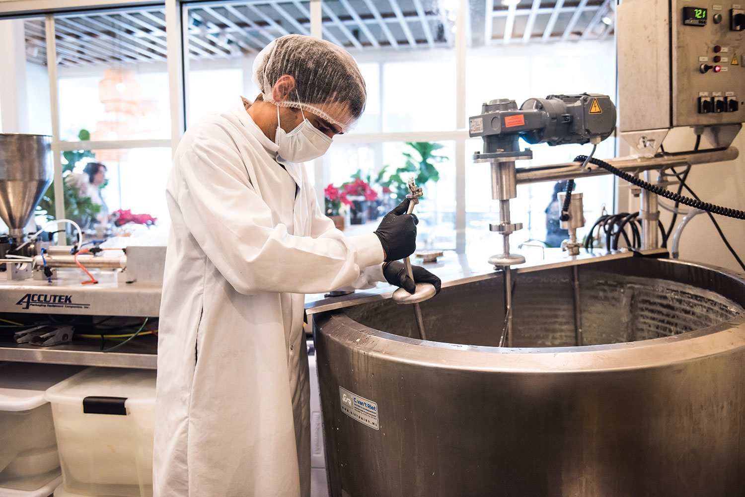 Checking the milk in the stainless steel vat pasteurizer 